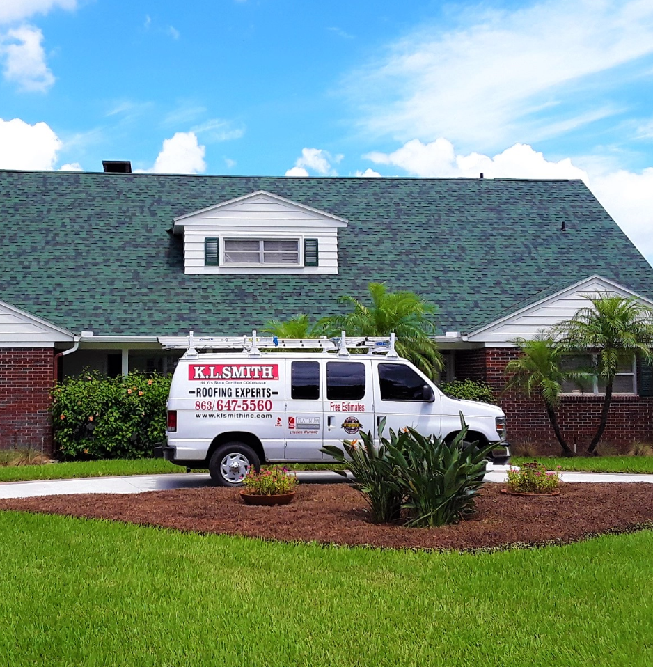 KL Smith Roofing van onsite at a residential home in Lakeland, FL, with green shingles.